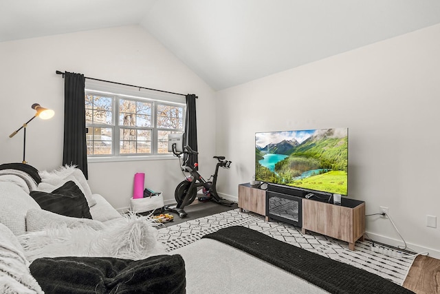 living room featuring light wood finished floors, baseboards, and lofted ceiling