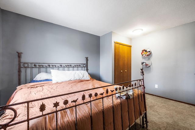 bedroom featuring a closet, baseboards, a textured ceiling, and carpet flooring