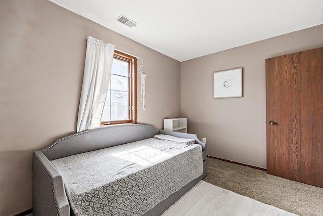 bedroom featuring visible vents, baseboards, and carpet