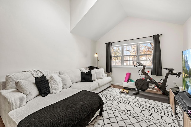 living room featuring wood finished floors, vaulted ceiling, and baseboards