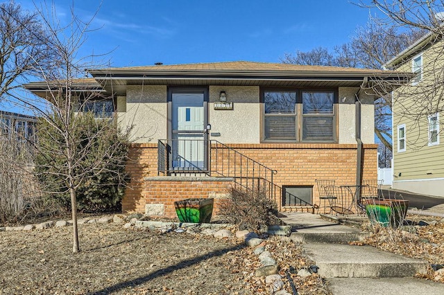 view of front of home featuring brick siding and stucco siding