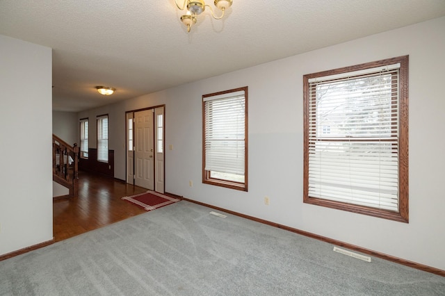 carpeted entrance foyer with a textured ceiling