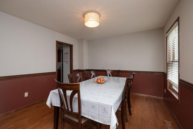 dining area featuring dark hardwood / wood-style floors and a textured ceiling