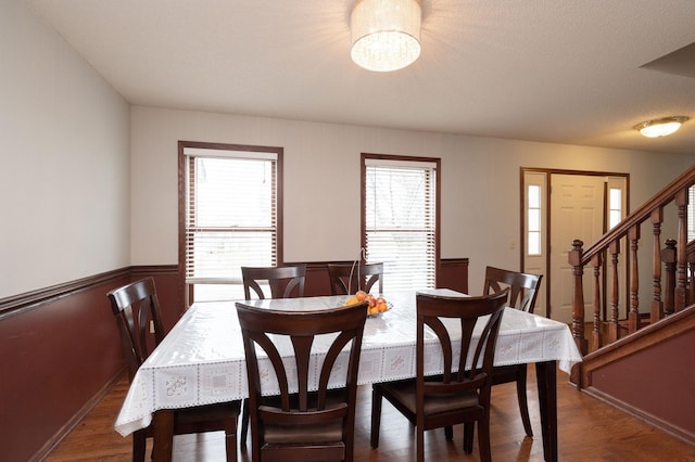 dining area with dark wood-type flooring and a chandelier