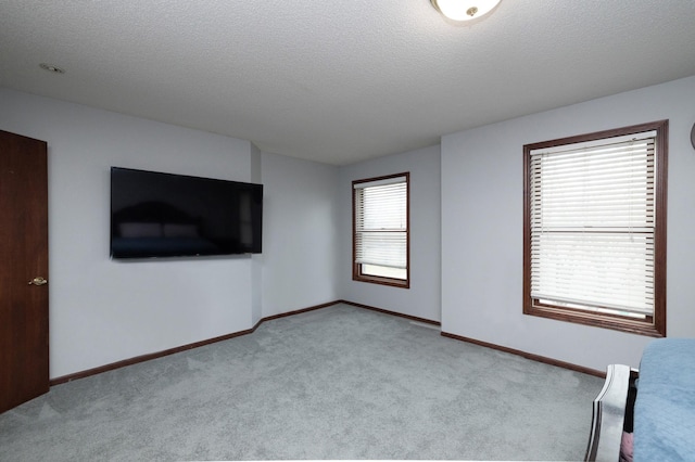 unfurnished bedroom featuring light carpet and a textured ceiling