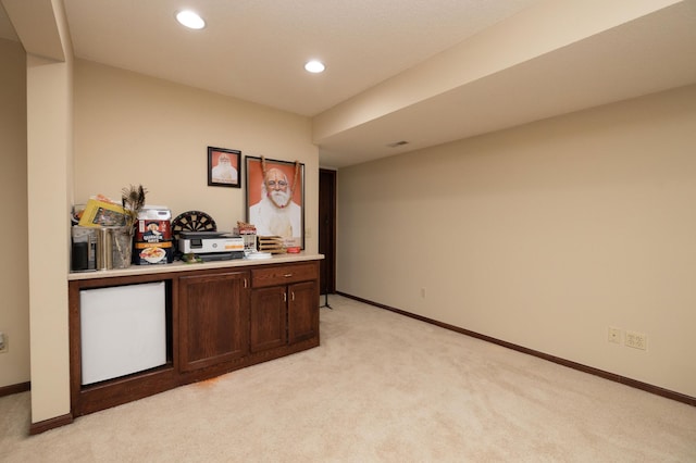 bar with fridge, light carpet, and dark brown cabinetry