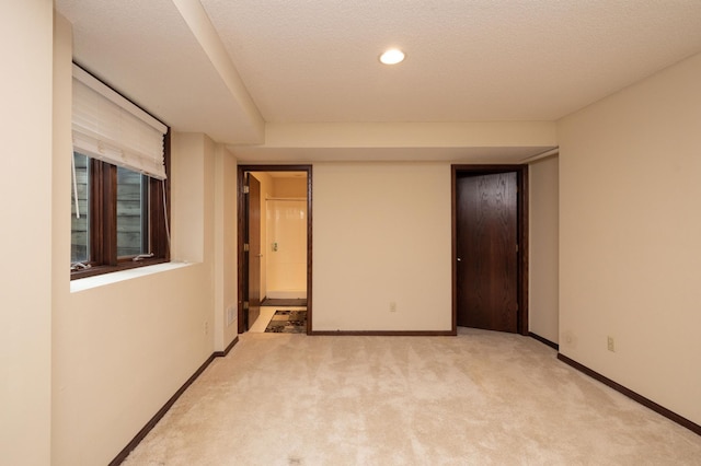 carpeted empty room with a textured ceiling