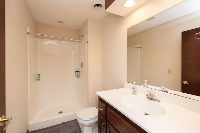 bathroom featuring vanity, toilet, and a shower