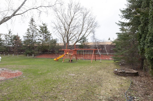 view of yard featuring a playground and an outdoor fire pit