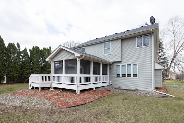 rear view of property with a lawn, a sunroom, and a deck