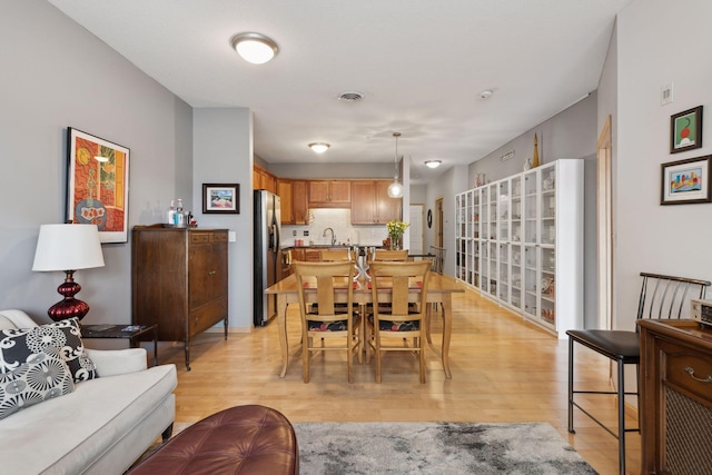 dining space with visible vents and light wood-style floors