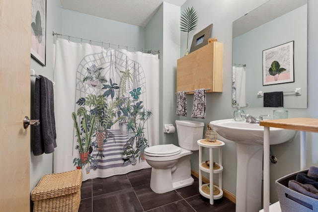 full bath with a shower with shower curtain, a sink, and toilet