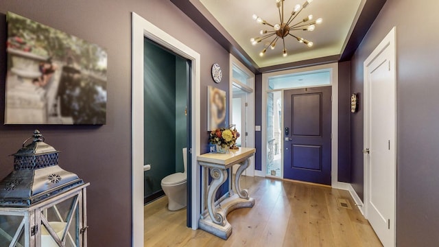 foyer entrance with an inviting chandelier and light hardwood / wood-style floors