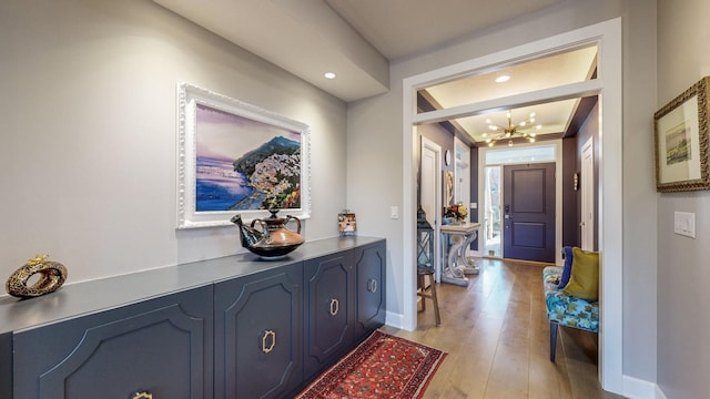 foyer entrance with an inviting chandelier and light hardwood / wood-style flooring