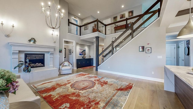 living room with a towering ceiling and light hardwood / wood-style flooring