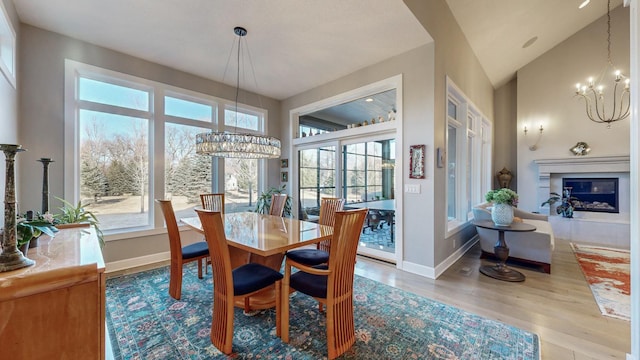 dining room featuring high vaulted ceiling, hardwood / wood-style floors, and a notable chandelier