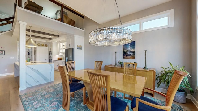 dining space with light wood-type flooring and a notable chandelier