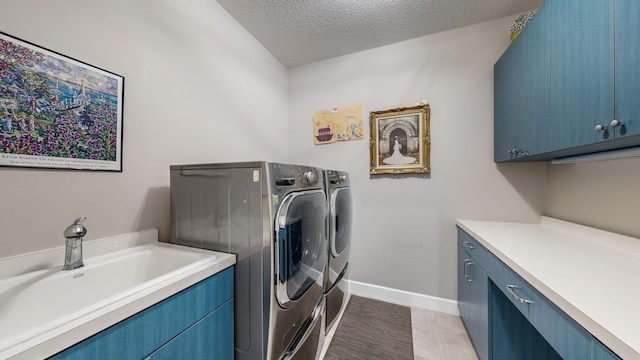 clothes washing area featuring separate washer and dryer, sink, cabinets, light tile patterned floors, and a textured ceiling