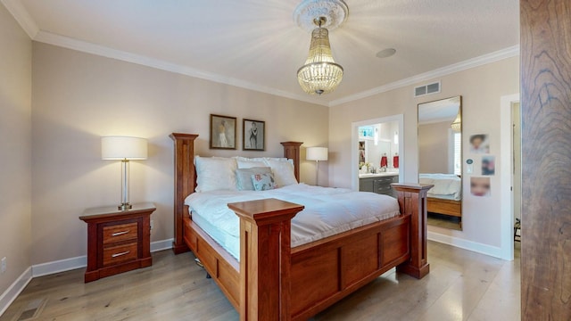 bedroom featuring crown molding, connected bathroom, light hardwood / wood-style floors, and a notable chandelier