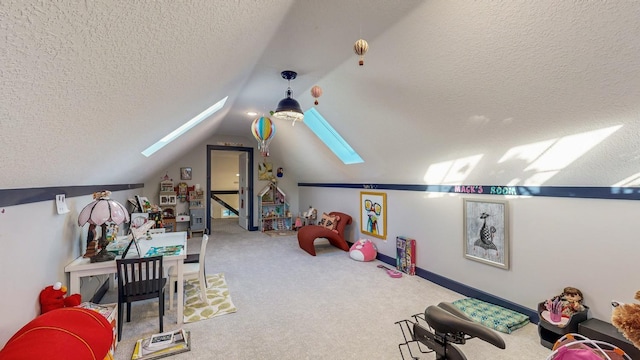 rec room featuring carpet flooring, vaulted ceiling with skylight, and a textured ceiling