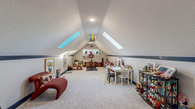 recreation room with a textured ceiling, carpet floors, and vaulted ceiling with skylight