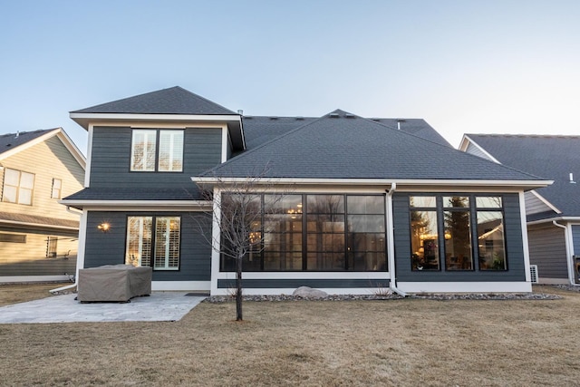 rear view of house with a patio and a yard