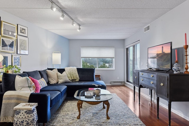 living room featuring hardwood / wood-style flooring, track lighting, a textured ceiling, and a baseboard heating unit