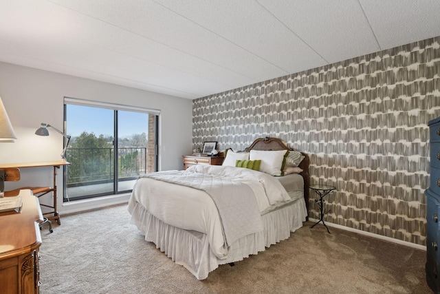 bedroom featuring baseboards, wallpapered walls, access to exterior, an accent wall, and carpet flooring