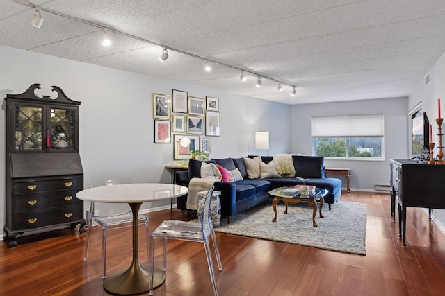 living room featuring dark wood finished floors, visible vents, and a textured ceiling