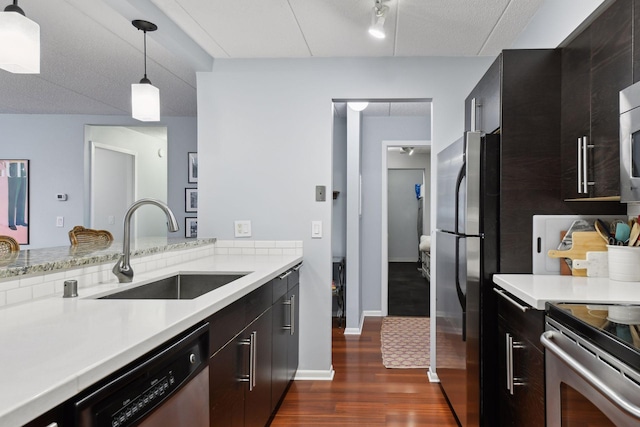 kitchen featuring dark wood finished floors, stainless steel appliances, light countertops, and a sink