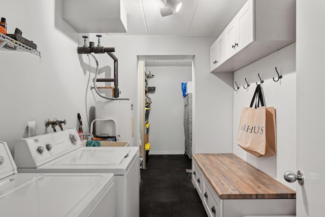 laundry room featuring cabinet space, separate washer and dryer, baseboards, and a textured ceiling