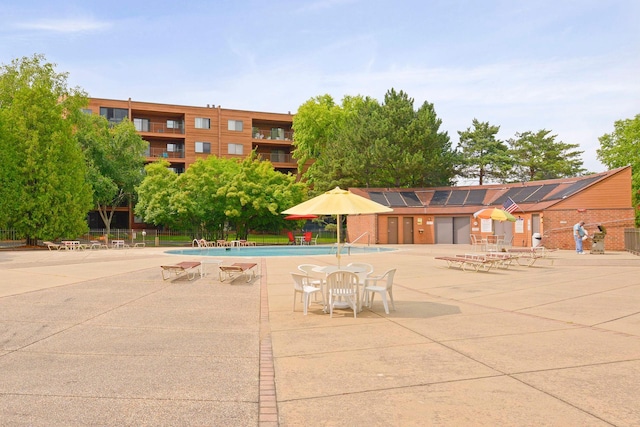 community pool with fence and a patio area