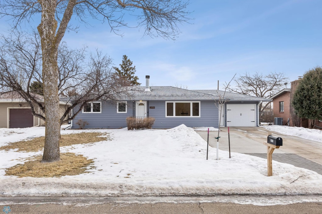 single story home featuring a garage and central AC unit