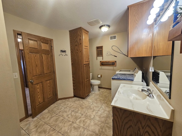 8785 Ilex Pl NW, Rice, MN 56367 - bathroom with separate washer and dryer, toilet, tile patterned flooring, baseboards, and vanity