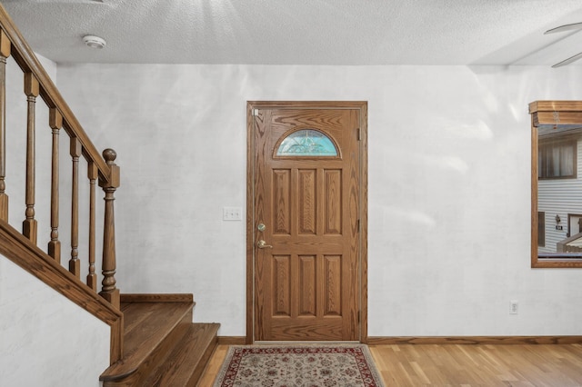 foyer entrance featuring light hardwood / wood-style flooring and a textured ceiling