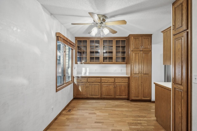 kitchen with ceiling fan, light hardwood / wood-style flooring, and a textured ceiling