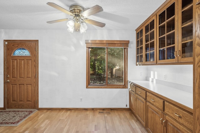 kitchen featuring ceiling fan, light hardwood / wood-style floors, and a textured ceiling