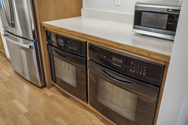 kitchen featuring stainless steel appliances, a mail area, and light hardwood / wood-style flooring