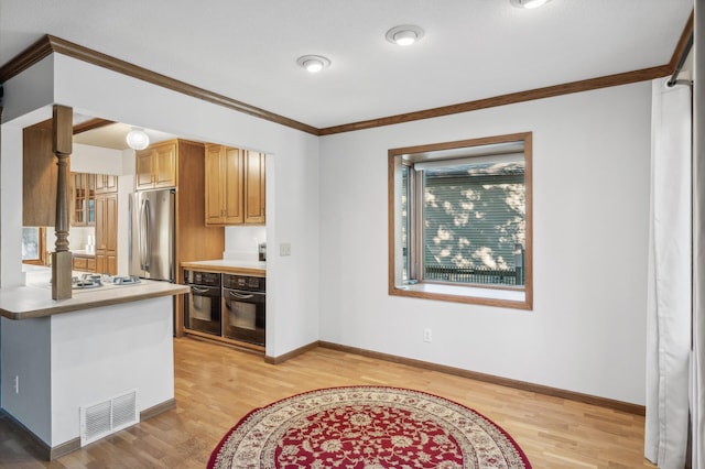 kitchen with ornamental molding, oven, stainless steel fridge, and light hardwood / wood-style flooring