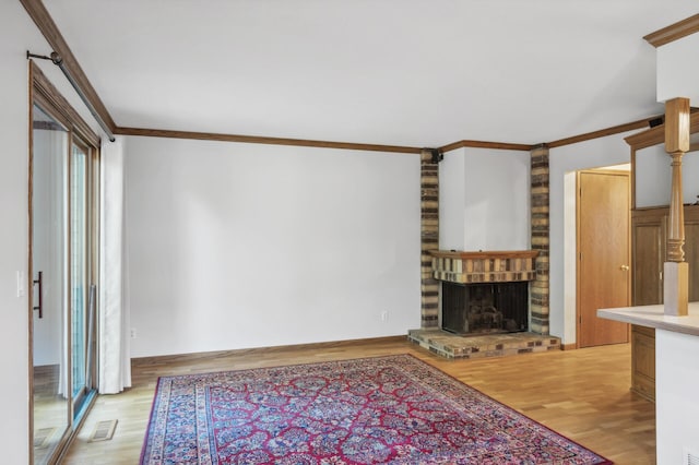 unfurnished living room featuring ornamental molding, a fireplace, and light hardwood / wood-style floors