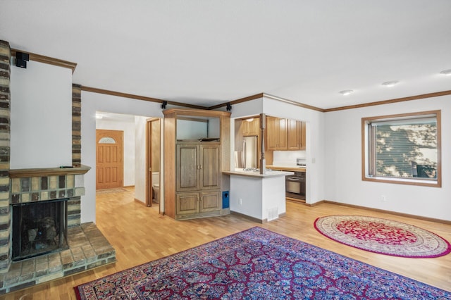 kitchen with ornamental molding, stainless steel refrigerator, and light wood-type flooring