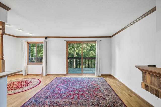 living room featuring crown molding, a healthy amount of sunlight, and light hardwood / wood-style floors