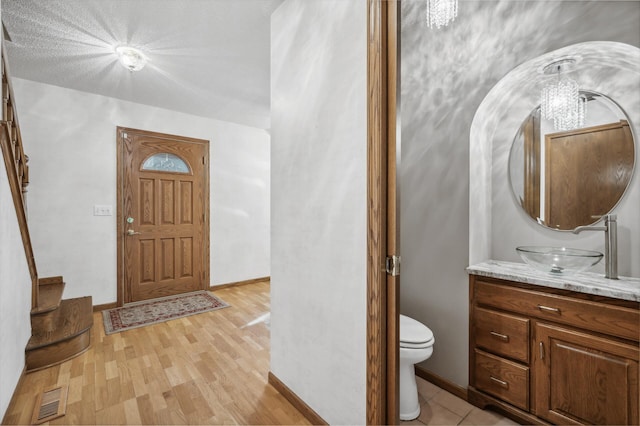 foyer entrance with light hardwood / wood-style floors and sink