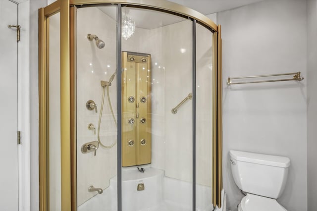 bathroom with a shower with door and toilet