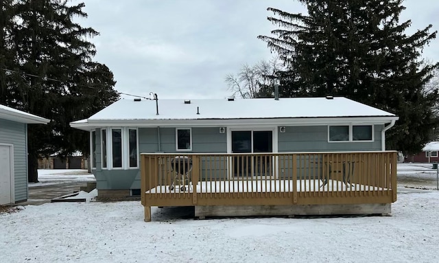 snow covered house with a deck