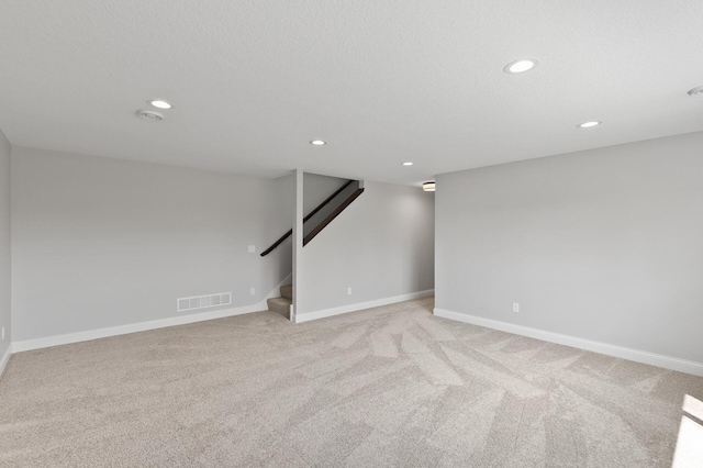 unfurnished room featuring light carpet and a textured ceiling