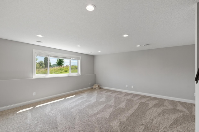 carpeted empty room with a textured ceiling