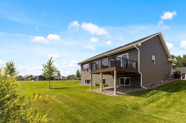 rear view of property with a wooden deck and a lawn