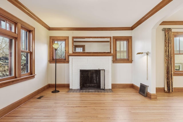 living room with ornamental molding, a fireplace, and light hardwood / wood-style flooring