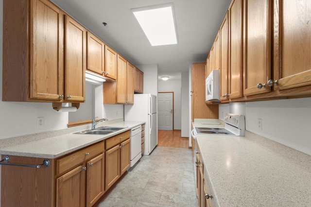 kitchen featuring sink, white appliances, and a skylight